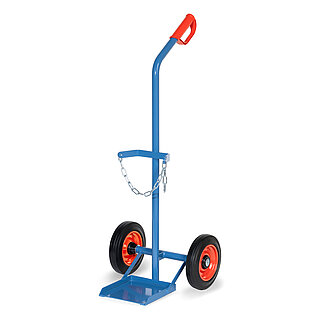 eine breite blaue FETRA® Karre aus Stahlrohr für Stahlflaschentransport mit dreiseitig umrandeter Ladeschaufel, Vollgummi-Bereifung auf roten Felgen, rotem Handgriff auf nach hinten geknicktem Schiebebügel und Kettensicherung für die Gasflasche, freigestellt auf weißem Hintergrund
