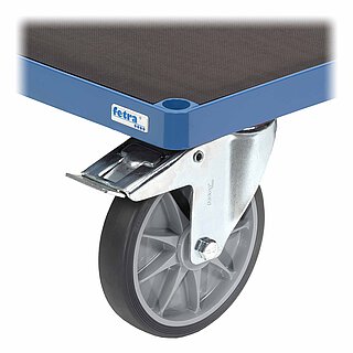 Detailansicht eines blauen FETRA® Plattformwagens aus Profilstahl mit Steckloch an der Ecke, dunkelbraunem, leicht strukturiertem Einlegeboden aus wasserfester Siebdruckplatte auf Sperrholzbasis, einer feststellbaren Lenkrolle mit dunkelgrauer TPE-Bereifung auf Metallfelge mit Sternmuster und darüberliegendem, verzinktem Feststellhebel, freigestellt auf weißem Hintergrund