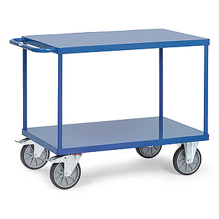 ein blauer FETRA® Tischwagen aus Stahlrohr und Profilstahl mit zwei Etagen, Schiebebügel, bündigen Stahlblechplattformen, zwei Bockrollen vorne und zwei feststellbaren Lenkrollen hinten, freigestellt auf weißem Hintergrund