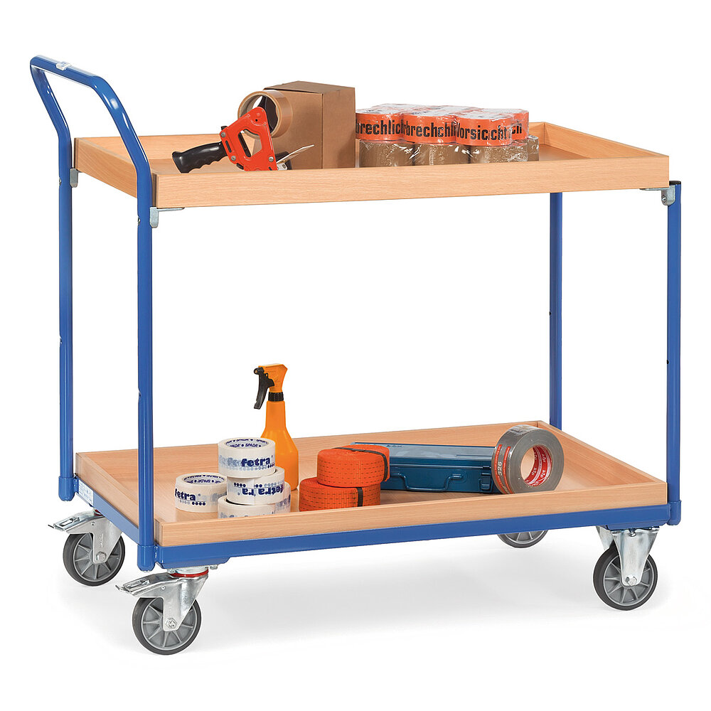 ein blauer FETRA® Tischwagen aus Stahlrohr und Profilstahl mit zwei großflächigen Etagen, nach hinten gebogenem Schiebebügel, hellen aufgesetzten Holzrahmenkästen oben und unten, zwei Bockrollen vorne, zwei feststellbaren Lenkrollen hinten und beladen mit Klebebrollen und Klebeabroller, freigestellt auf weißem Hintergrund