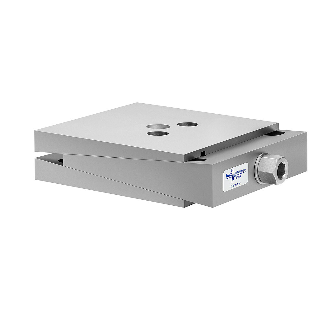 aus Ober-, Mittel- und Unterteil bestehender, quadratischer, höhenverstellbarer Maschinenschuh aus plangefrästem Metall, eingestellt auf minimale Höhe, silber-grau lackiert, mit keilförmigem Mittelteil mit mittig auf der Seite platzierter Sechskantschraube zur Höhenverstellung und zwei Löchern für Befestigungsschrauben im Oberteil, freigestellt auf weißem Hintergrund