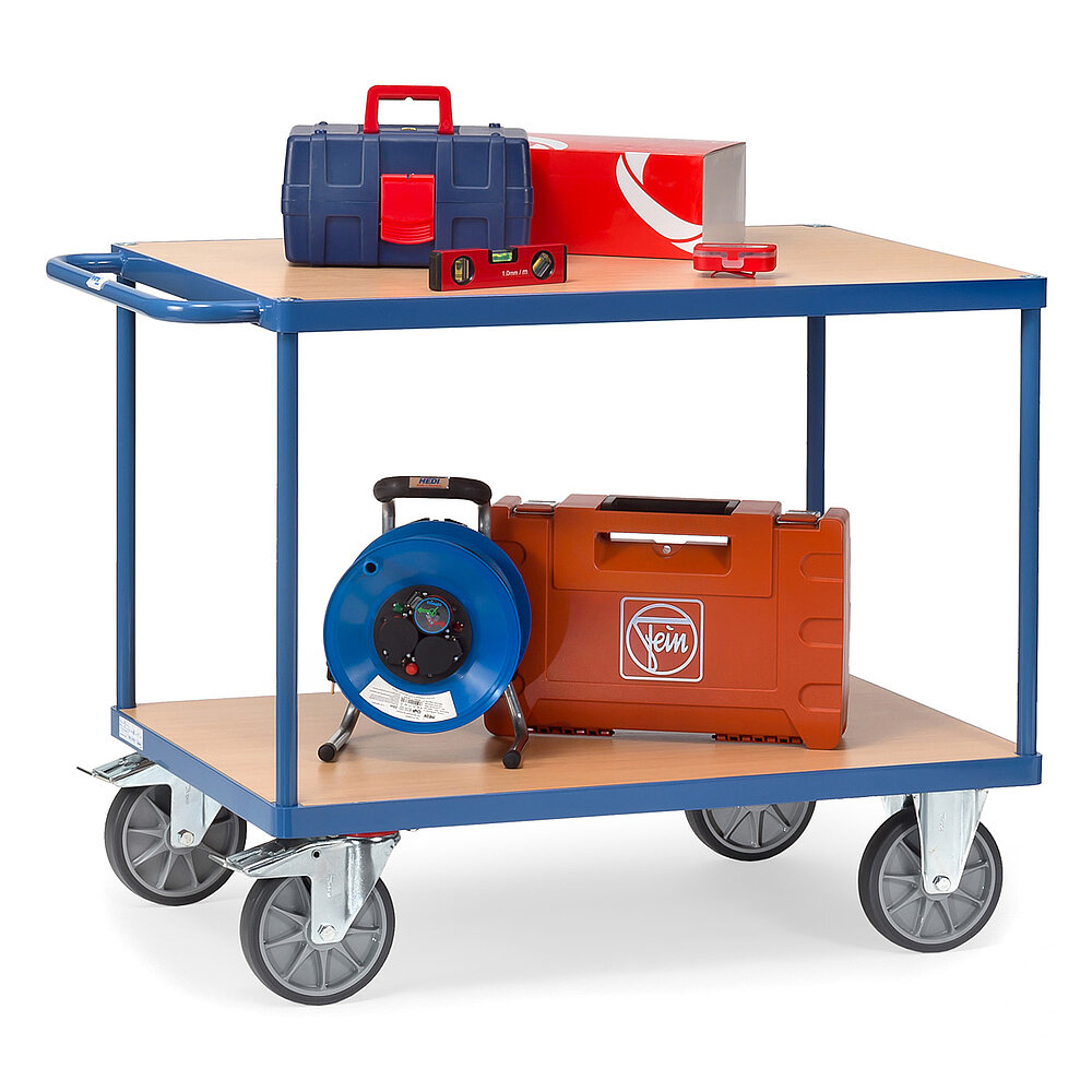 ein blauer FETRA® Tischwagen aus Stahlrohr und Profilstahl mit zwei Etagen, Schiebebügel, hellen Holzeinlegeböden, zwei Bockrollen vorne, zwei feststellbaren Lenkrollen hinten und beladen mit Koffern von Elektrowerkzeugen, freigestellt auf weißem Hintergrund
