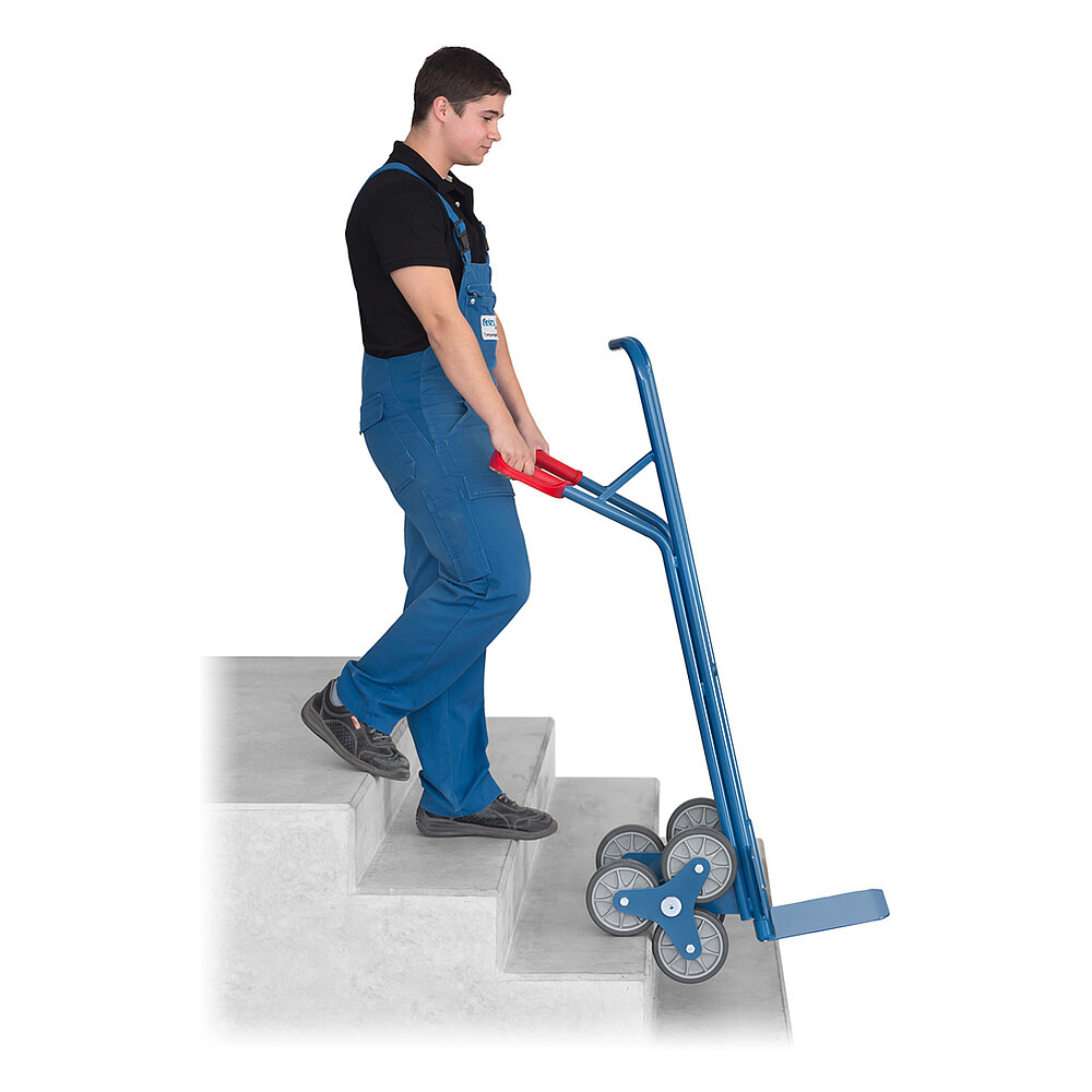 ein Logistiker mit einer blauen FETRA® Treppenkarre aus Stahlrohr mit dreiarmigem Radstern auf einer grauen Betontreppe