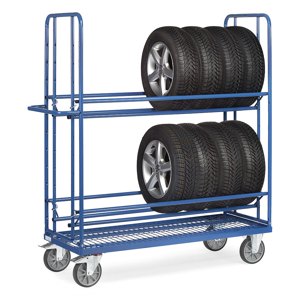ein blauer zweigeschoßiger FETRA® Reifenwagen aus Stahlrohr mit 4 Lenkrollen, davon 2 feststellbar, Drahtgitterboden, und beladen mit 8 hochkant stehenden PKW-Reifen auf Alufelgen, auf weißem Hintergrund