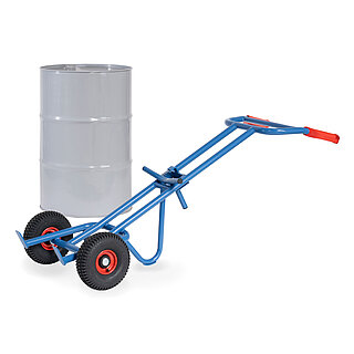 eine blaue FETRA® Karre aus Stahlrohr für den Transport von Fässern, mit zwei Rädern mit Luftbereifung auf roten Felgen, roten Handgriffen und geschwungener Stütze für Schräglage in Ruheposition, dahinter ein graues 200 Liter Fass aus Metall, freigestellt auf weißem Hintergrund
