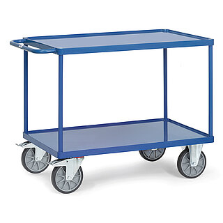 ein blauer FETRA® Tischwagen aus Stahlrohr und Profilstahl mit zwei Etagen, Schiebebügel, leicht vertieften Stahlblechwannen, zwei Bockrollen vorne und zwei feststellbaren Lenkrollen hinten, freigestellt auf weißem Hintergrund
