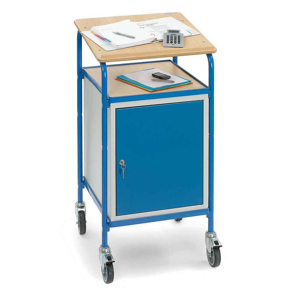 ein blaues FETRA® Rollpult mit Schrank, Ablagefläche und Schreibuntensilien auf schräger Pultfläche auf weißem Hintergrund