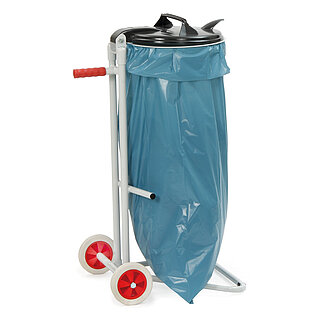 ein graues FETRA® Metallgestell mit zwei Transportrollen, rotem Handgriff und Haltering für Müllsäcke, einem darin eingespannten blauen Müllsack und einem darüber geschlossenen schwarzen Klappdeckel aus Kunststoff, freigestellt auf weißem Hintergrund