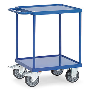 ein quadratischer blauer FETRA® Tischwagen aus Stahlrohr und Profilstahl mit zwei Etagen, Schiebebügel, leicht vertieften Stahlblechwannen, zwei Bockrollen vorne und zwei feststellbaren Lenkrollen hinten, freigestellt auf weißem Hintergrund