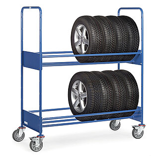 ein blauer zweigeschoßiger FETRA® Reifenwagen aus Stahlrohr mit 4 Lenkrollen, davon 2 feststellbar, und beladen mit 8 hochkant stehenden PKW-Reifen auf Alufelgen, auf weißem Hintergrund