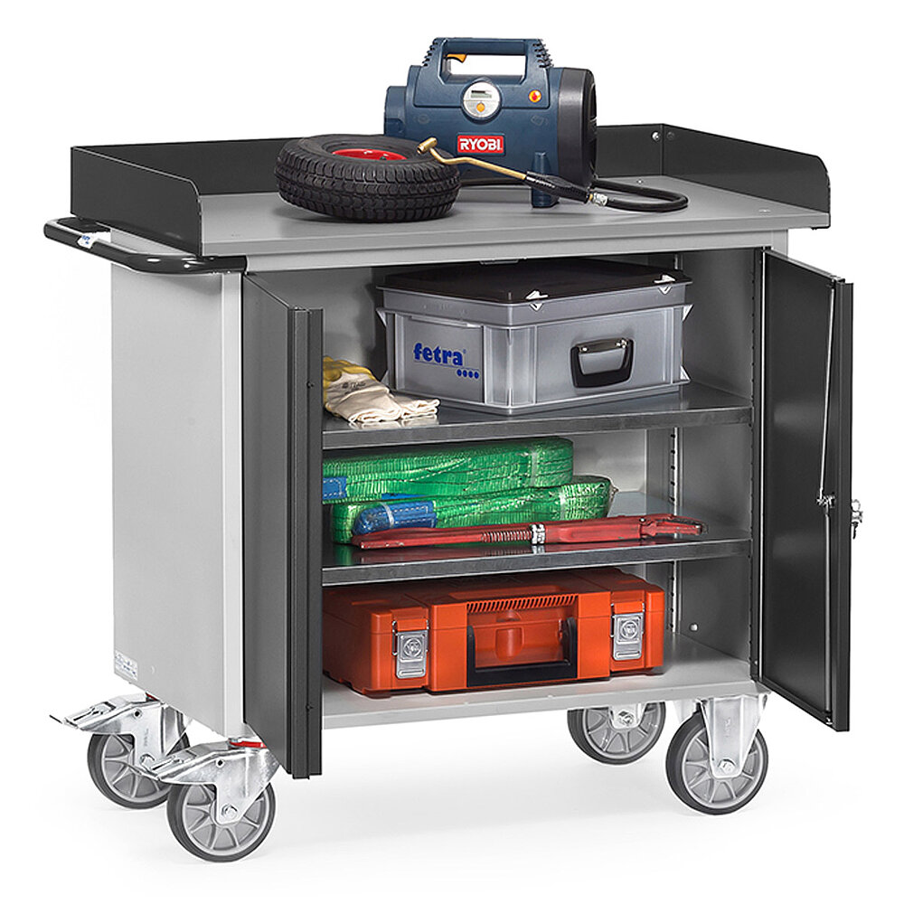 ein grauer FETRA® Werkstattwagen mit 2 geöffneten Schranktüren, Abrollrand und verschiedenen Utensilien auf weißem Hintergrund