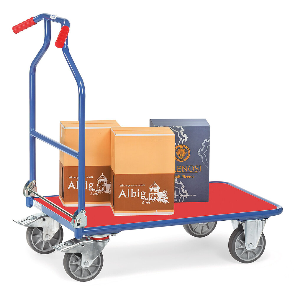 ein blauer FETRA® Klappwagen aus Stahlrohr mit tiefliegender rechteckiger Plattform aus rot beschichtetem Holz, abklappbarem Schiebebügel mit zwei roten nach hinten gebogenen Handgriffen, zwei Bockrollen vorne, zwei feststellbaren Lenkrollen hinten und beladen mit drei Weinkartons, freigestellt auf weißem Hintergrund