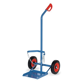 eine sehr breite blaue FETRA® Karre aus Stahlrohr für Stahlflaschentransport mit dreiseitig umrandeter Ladeschaufel, Vollgummi-Bereifung auf roten Felgen, rotem Handgriff auf nach hinten geknicktem Schiebebügel und Kettensicherung für die Gasflasche, freigestellt auf weißem Hintergrund