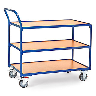 ein blauer FETRA® Tischwagen aus Stahlrohr und Profilstahl mit drei großflächigen Etagen, nach hinten gebogenem Schiebebügel, hellen Holzeinlegeböden, zwei Bockrollen vorne und zwei feststellbaren Lenkrollen hinten, freigestellt auf weißem Hintergrund