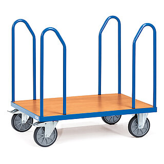 ein blauer FETRA® Plattformwagen aus Profilstahl mit vier an den Ecken eingesteckten Stahlrohrbügeln, hellem Holzeinlegeboden, zwei Bockrollen vorne und zwei feststellbaren Lenkrollen hinten, freigestellt auf weißem Hintergrund