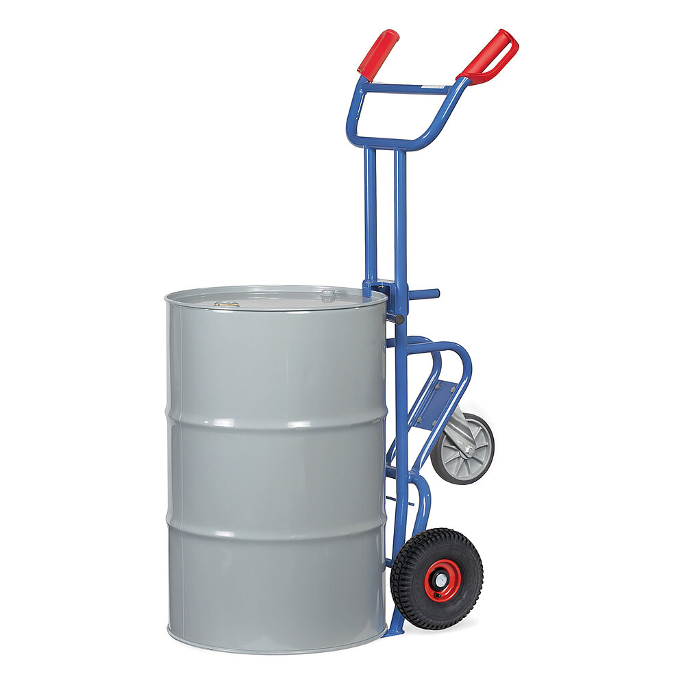 eine blaue aufrecht stehende FETRA® Karre aus Stahlrohr für den Transport von Fässern, mit zwei Rädern mit Luftbereifung auf roten Felgen, roten Handgriffen und geschwungener Stütze für Schräglage in Ruheposition mit zusätzlichem dritten drehbaren Stützrad, beladen mit einem grauen 200 Liter Fass aus Metall, freigestellt auf weißem Hintergrund