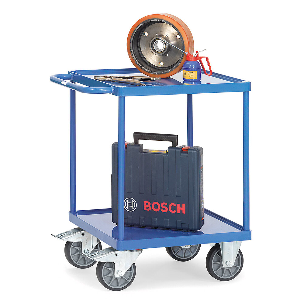 ein quadratischer blauer FETRA® Tischwagen aus Stahlrohr und Profilstahl mit zwei Etagen, Schiebebügel, leicht vertieften Stahlblechwannen, zwei Bockrollen vorne, zwei feststellbaren Lenkrollen hinten und beladen mit einem Elektrowerkzeugkoffer und einem Handöler, freigestellt auf weißem Hintergrund