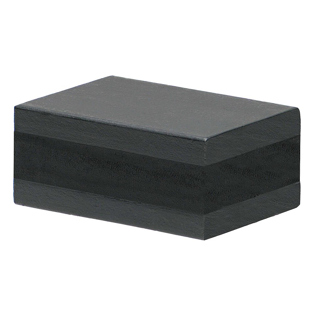 ein schwarzes längliches Elastomer einvulkanisiert zwischen zwei schwarz lackierten Metallplatten auf weißem Hintergrund
