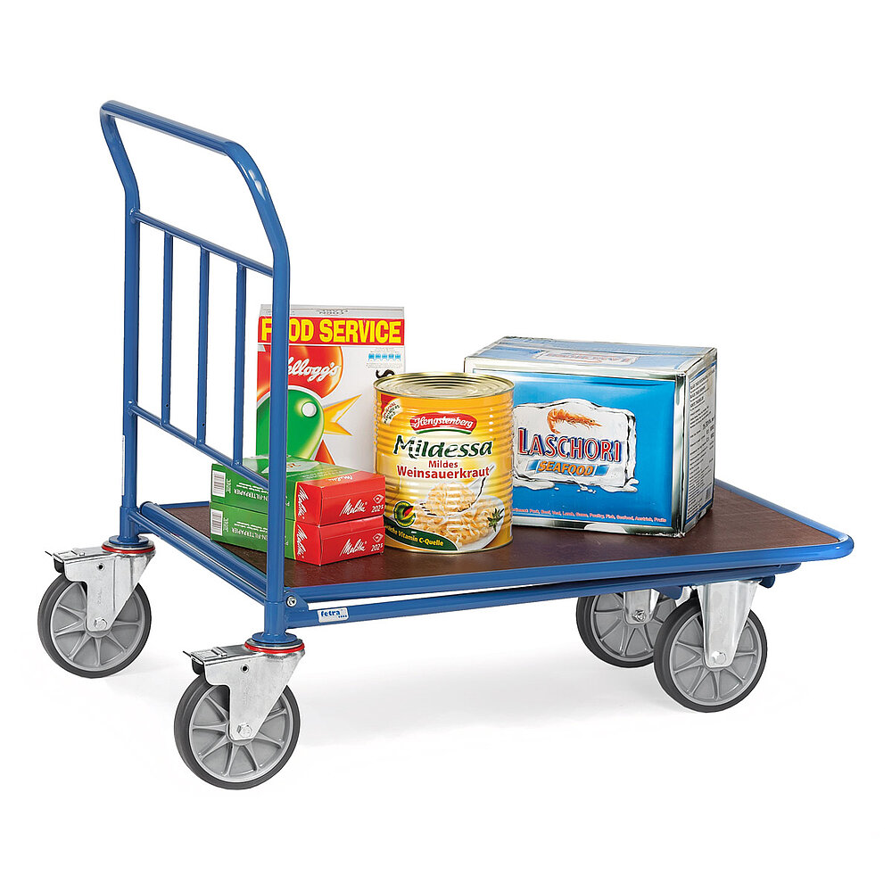 ein blauer FETRA® Plattformwagen mit Schiebebügel aus Stahlrohr, zwei Bockrollen vorne, zwei feststellbaren Lenkrollen hinten, brauner Ladeplattform aus Holz und beladen mit verschiedenen Lebensmitteln, freigestellt auf weißem Hintergrund