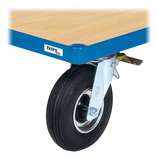 Detailansicht eines blauen FETRA® Plattformwagens aus Profilstahl mit Steckloch an der Ecke, hellem Holzeinlegeboden und einer feststellbaren Lenkrolle mit schwarzer Luftbereifung und verzinktem Feststellhebel, freigestellt auf weißem Hintergrund