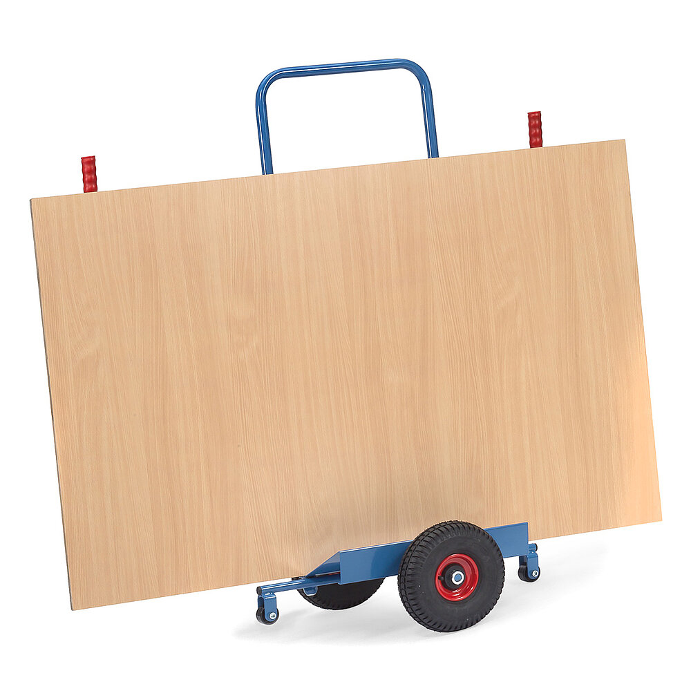 eine blaue nach vorne geneigte FETRA® Karre zum Transport von Platten mit zwei schwarzen Gummireifen, zwei roten Handgriffen und einer großen braunen Holzplatte auf weißem Hintergrund