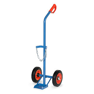 eine blaue FETRA® Karre aus Stahlrohr für Stahlflaschentransport mit dreiseitig umrandeter Ladeschaufel, Vollgummi-Bereifung auf roten Felgen, rotem Handgriff auf nach hinten geknicktem Schiebebügel und Kettensicherung für die Gasflasche, freigestellt auf weißem Hintergrund