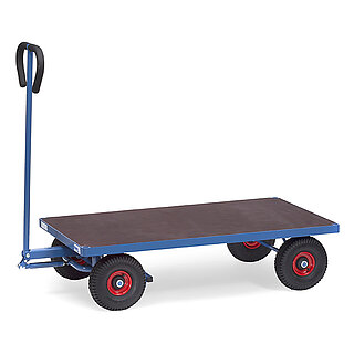 ein blauer 2-achsiger FETRA® Handwagen mit Lenkdeichsel, flacher brauner Ladeplattform aus Holz und Luftbereifung auf weißem Hintergrund