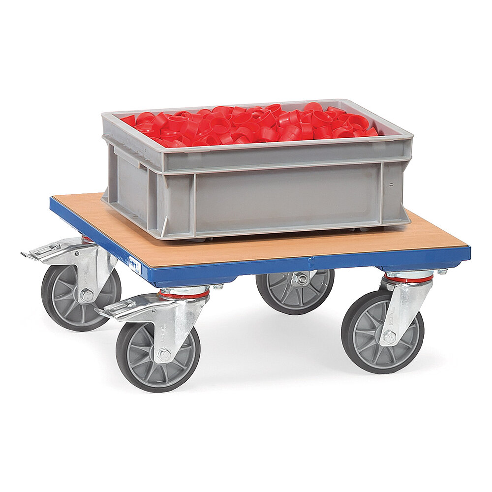 ein blauer FETRA® Kistenroller aus geschweißtem Profilstahl mit tiefliegender bündig eingepasster heller Holzplattform und vier Lenkrollen, die hinteren feststellbar und beladen mit einer grauen Kunststoffkiste, befüllt mit roten Plastikdeckeln, freigestellt auf weißem Hintergrund