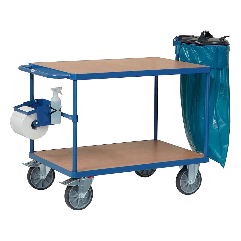 ein blauer FETRA® Tischwagen aus Stahlrohr und Profilstahl mit zwei Etagen, Schiebebügel, hellen Holzeinlegeböden, zwei Bockrollen vorne, zwei feststellbaren Lenkrollen hinten, angebauter Papierhalterolle, angebautem Abfallsackhalter und angebautem Flaschenhalter, freigestellt auf weißem Hintergrund